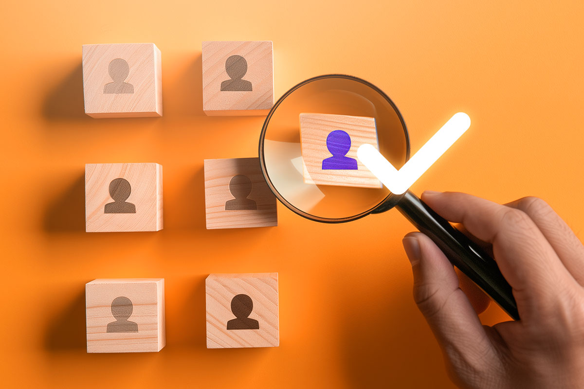 Magnifying glass hovering over a person icon with a checkmark nearby