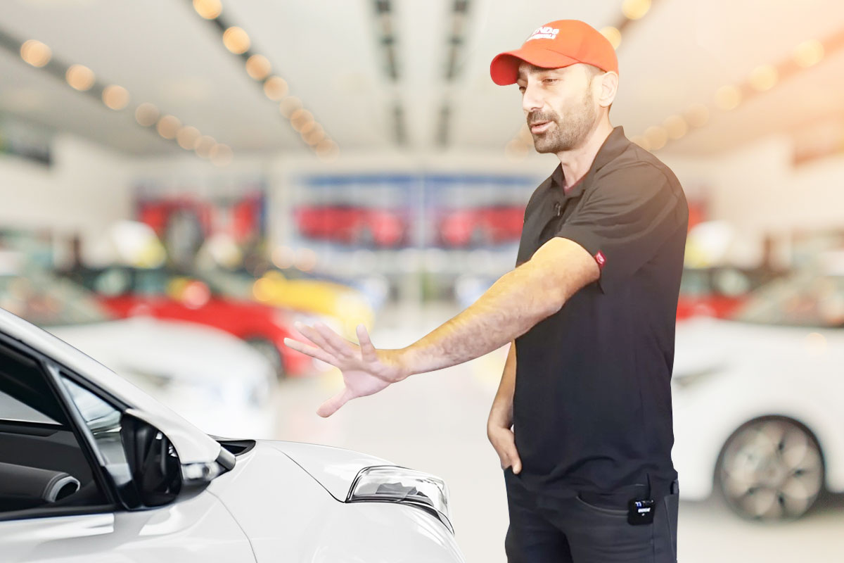 Owner of Legends Car & Van Rentals gesturing to a vehicle