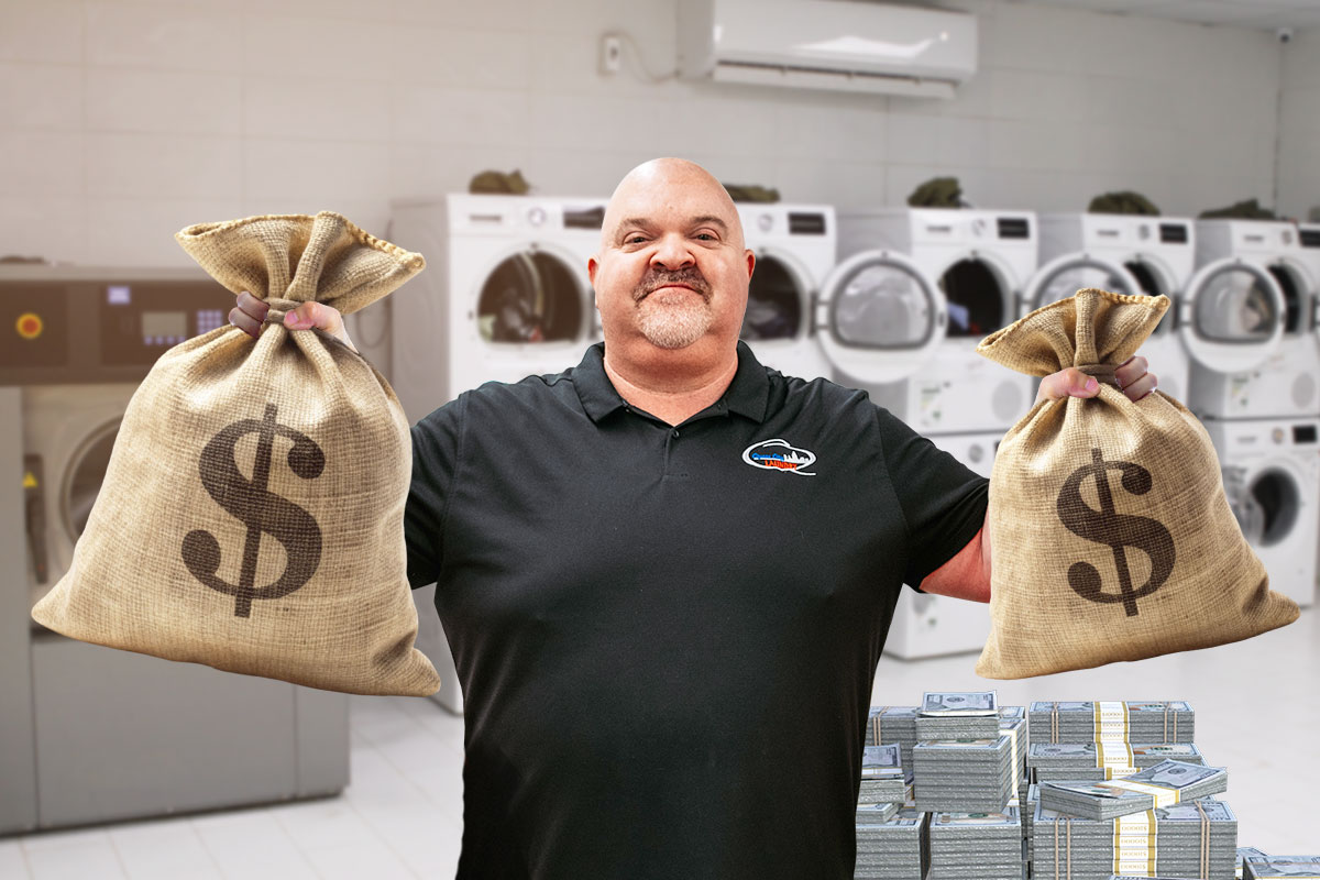 Dave Menz, owner of Queen City Laundry, holding two burlap bags of cash inside a laundromat