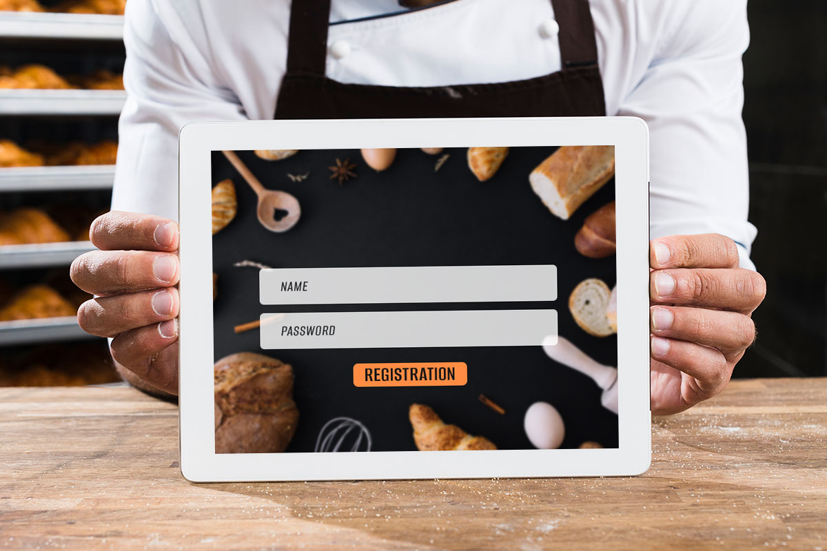 A baker holding a tablet prompting the user to sign in with their name and password to register