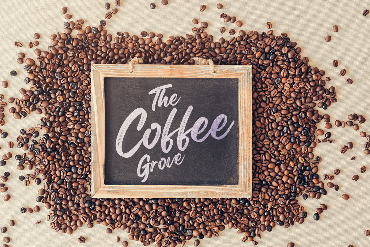 379 Coffee Shop Names You’ll Adore! 5 A chalkboard with the business name The Coffee Grove sitting on top of a pile of coffee beans.