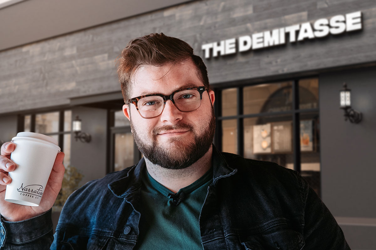 379 Coffee Shop Names You’ll Adore! 4 A coffee shop business owner holding a to-go cup outside of a cafe called The Demitasse.