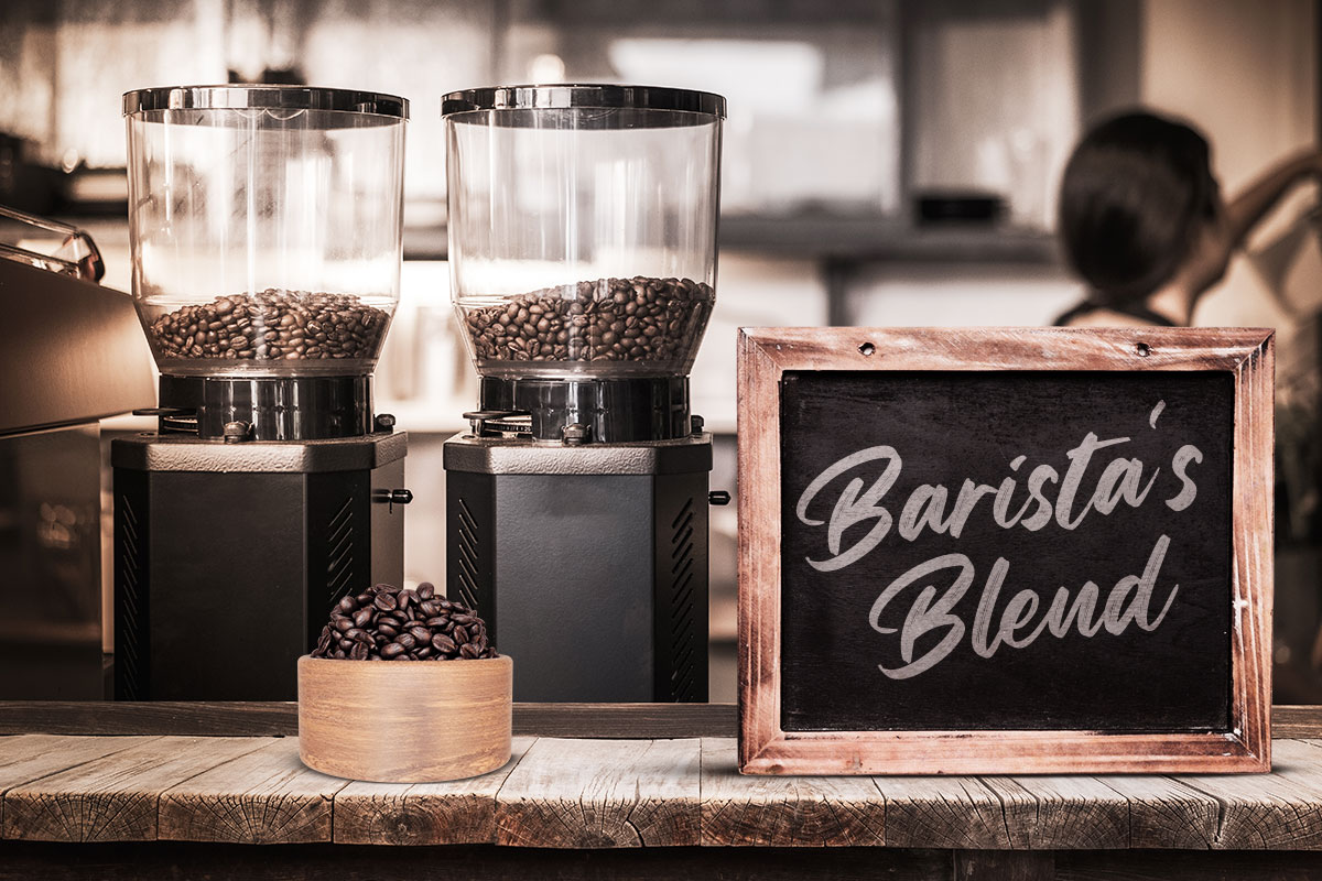 379 Coffee Shop Names You’ll Adore! 3 Two coffee grinders full of beans on a counter at a coffee shop next to a chalkboard sign that says Baristas Blend.