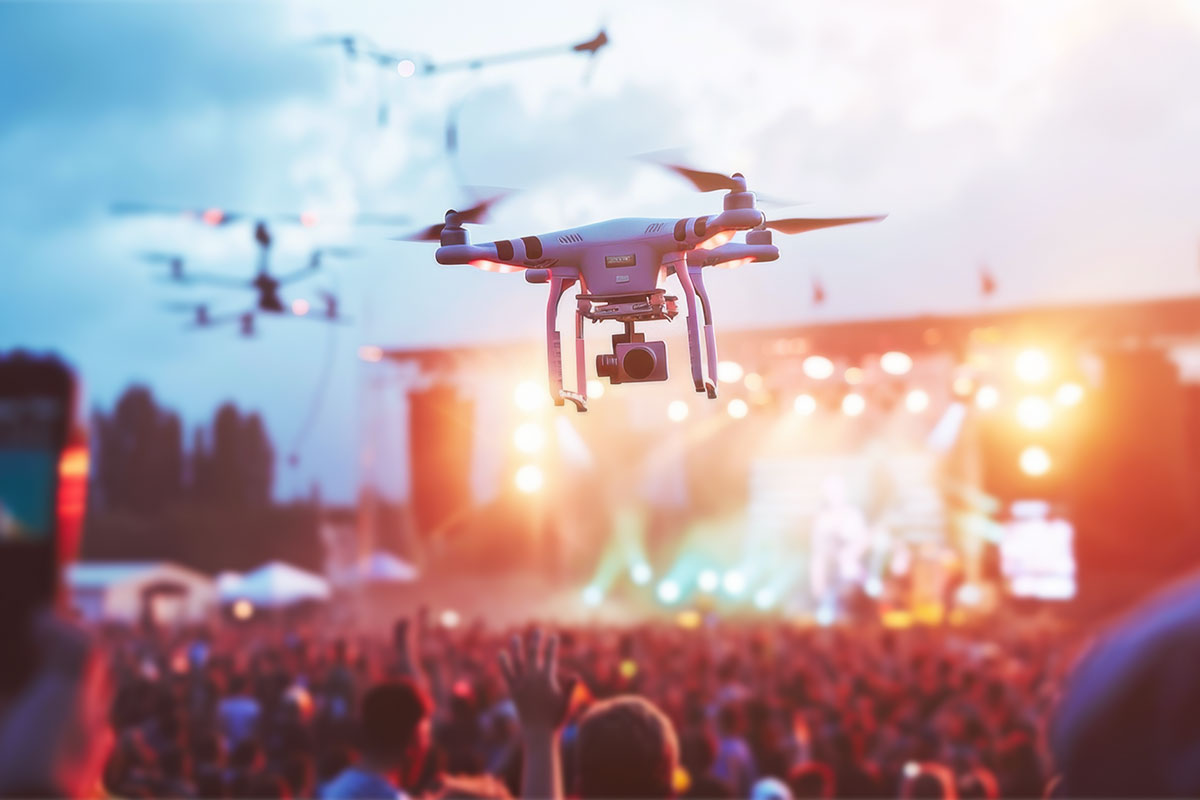 Several drones flying over an outdoor concert.