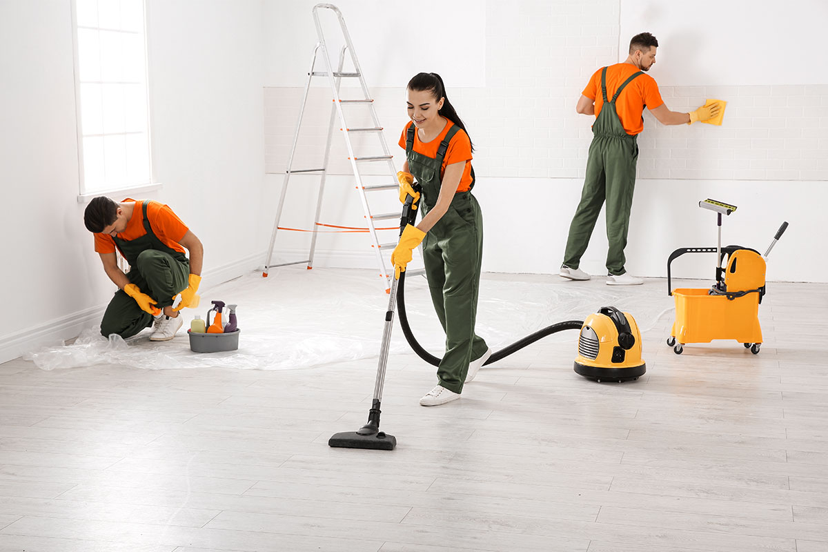 A team of three residential cleaners working in a new house.