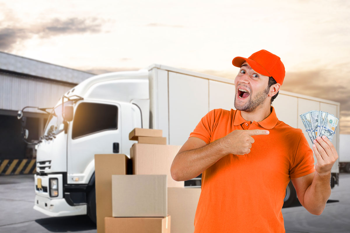 A trucking company owner holding a fan of cash while standing in front of a box truck.