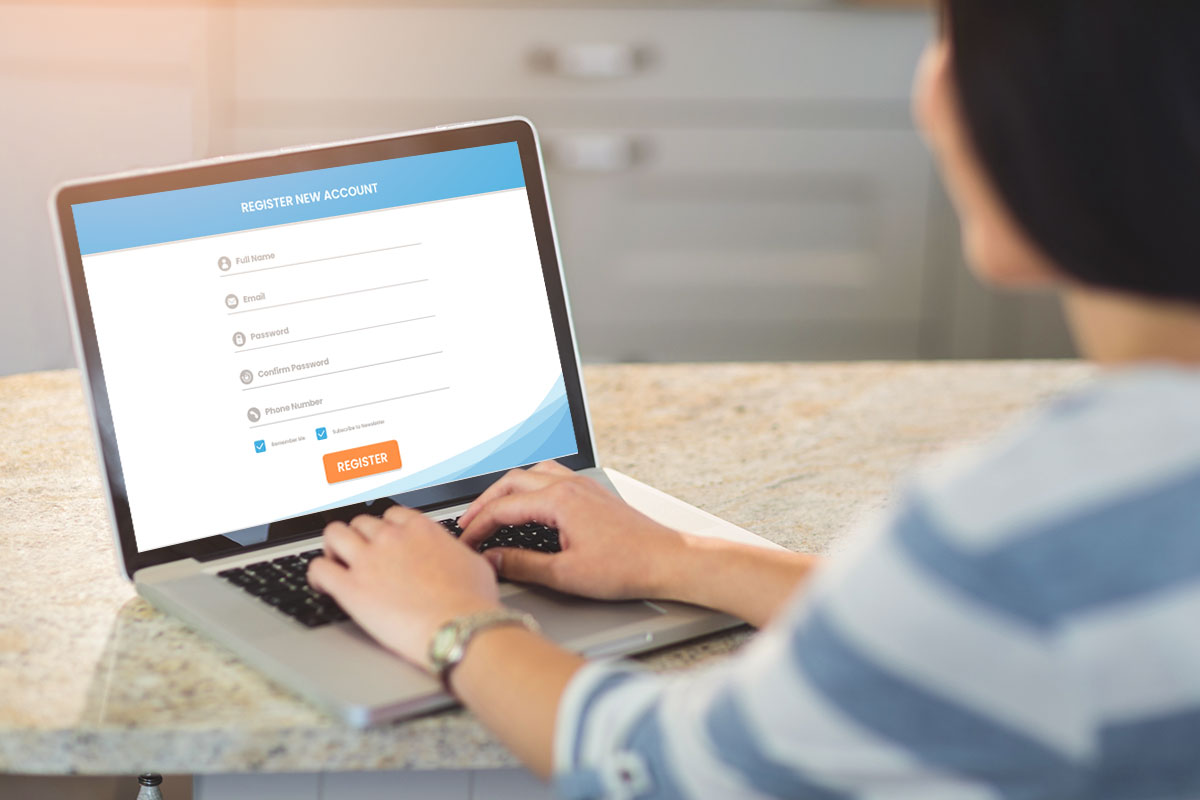 A woman using a laptop to register a new account for her business.