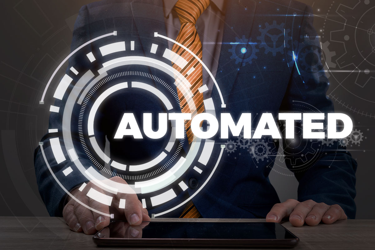 A businessman working in the background with the word automated and a gear symbol in the foreground.