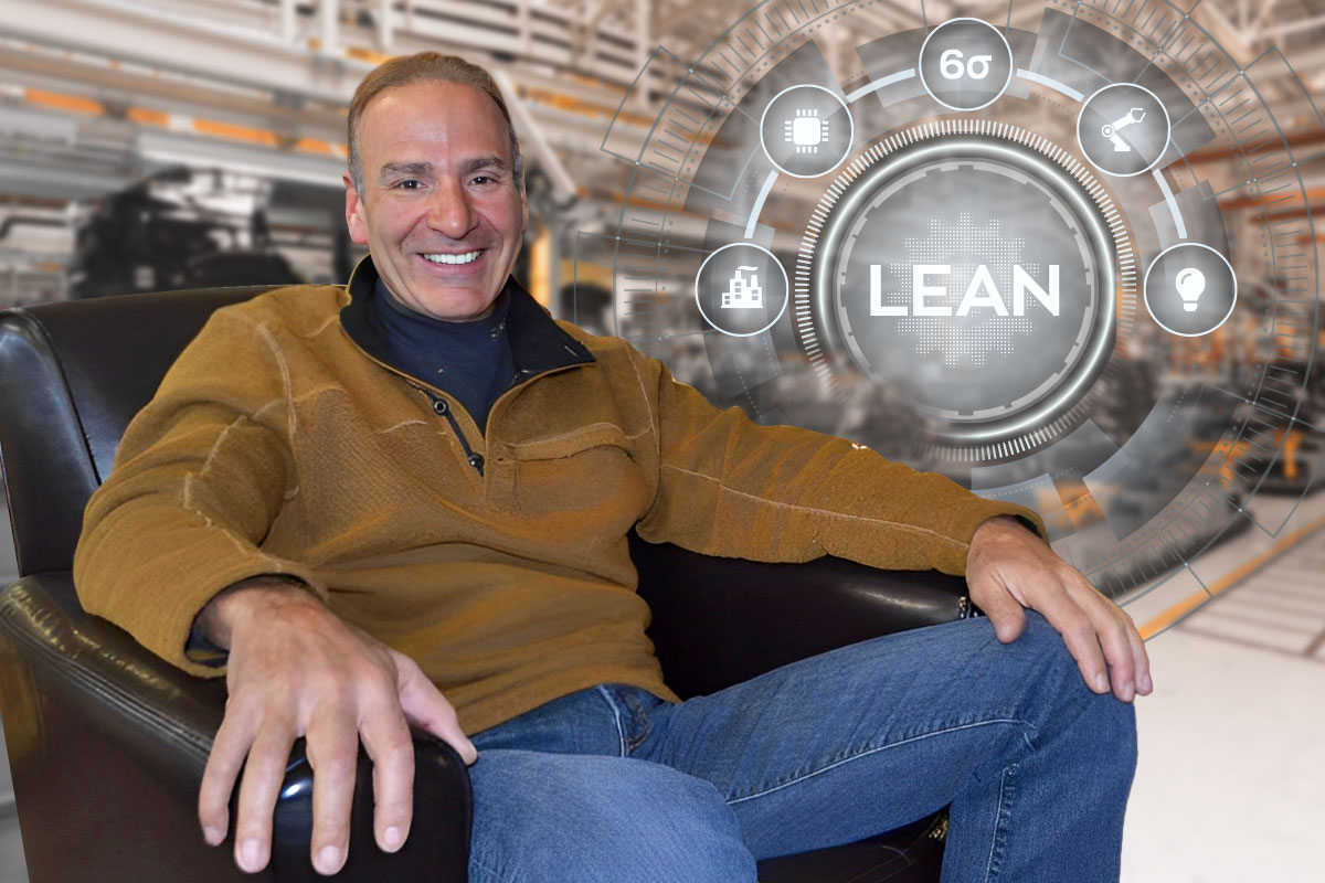Paul Akers sitting in a chair while the word lean and various manufacturing symbols hover in the air nearby.