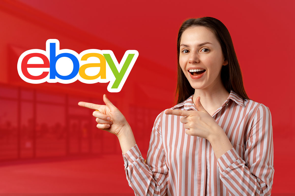 A woman pointing to the eBay logo with both hands.