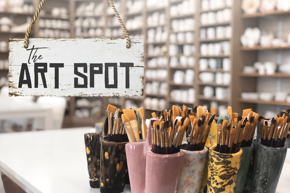 A ceramics store with a hanging sign that says The Art Spot.