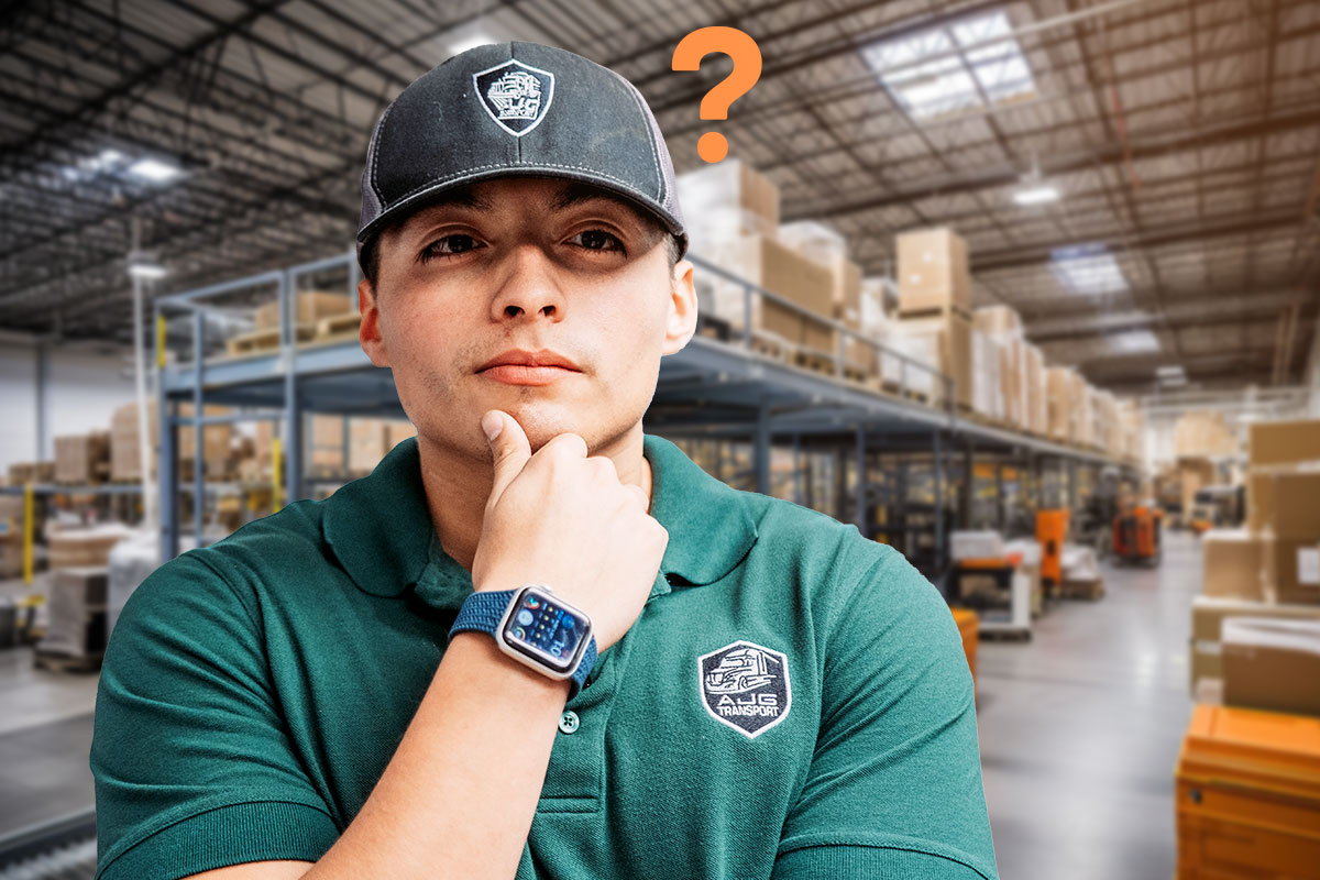 250 Logistic Company Names 10 The owner of AJG Transport holding his chin while standing in a warehouse full of packages.