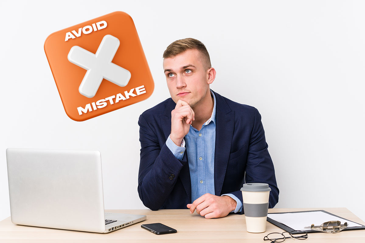 Grants 101 for Small Business Owners 81 A business owner working at a desk and holding his chin next to a floating button that says avoid mistake.