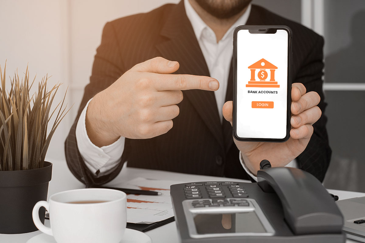 A businessman pointing to a mobile banking login screen.