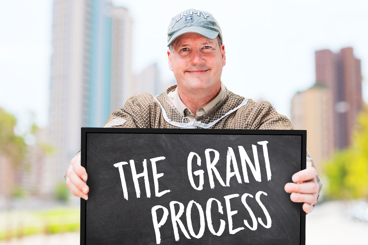 Grants 101 for Small Business Owners 78 The owner of Secret Garden Bees holding a sign that says the grant process.