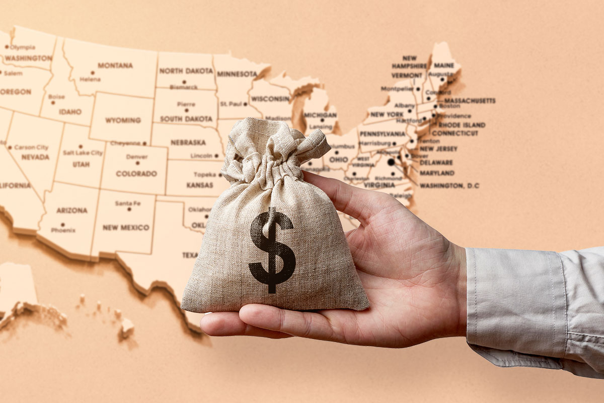 Grants 101 for Small Business Owners 77 A hand holding a bag of money over a wooden map of the United States.