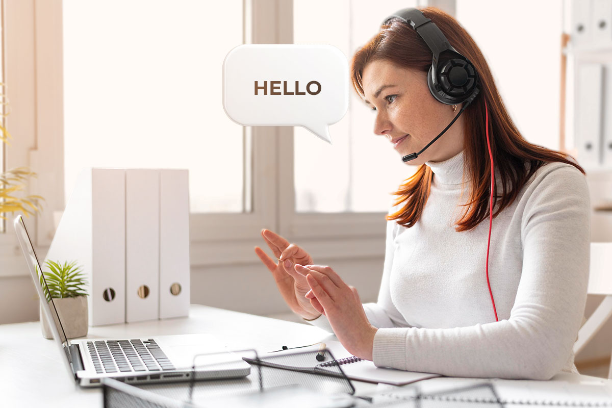 Small Business Marketing 10 A telemarketer wearing a headset and saying hello while on a call.