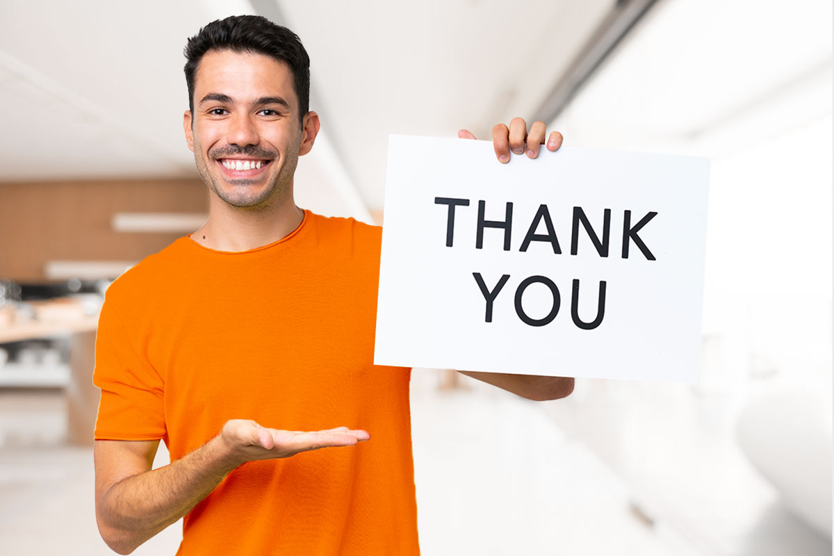 Business Thank You Messages to Customers 3 A business owner holding up a large card that says thank you.