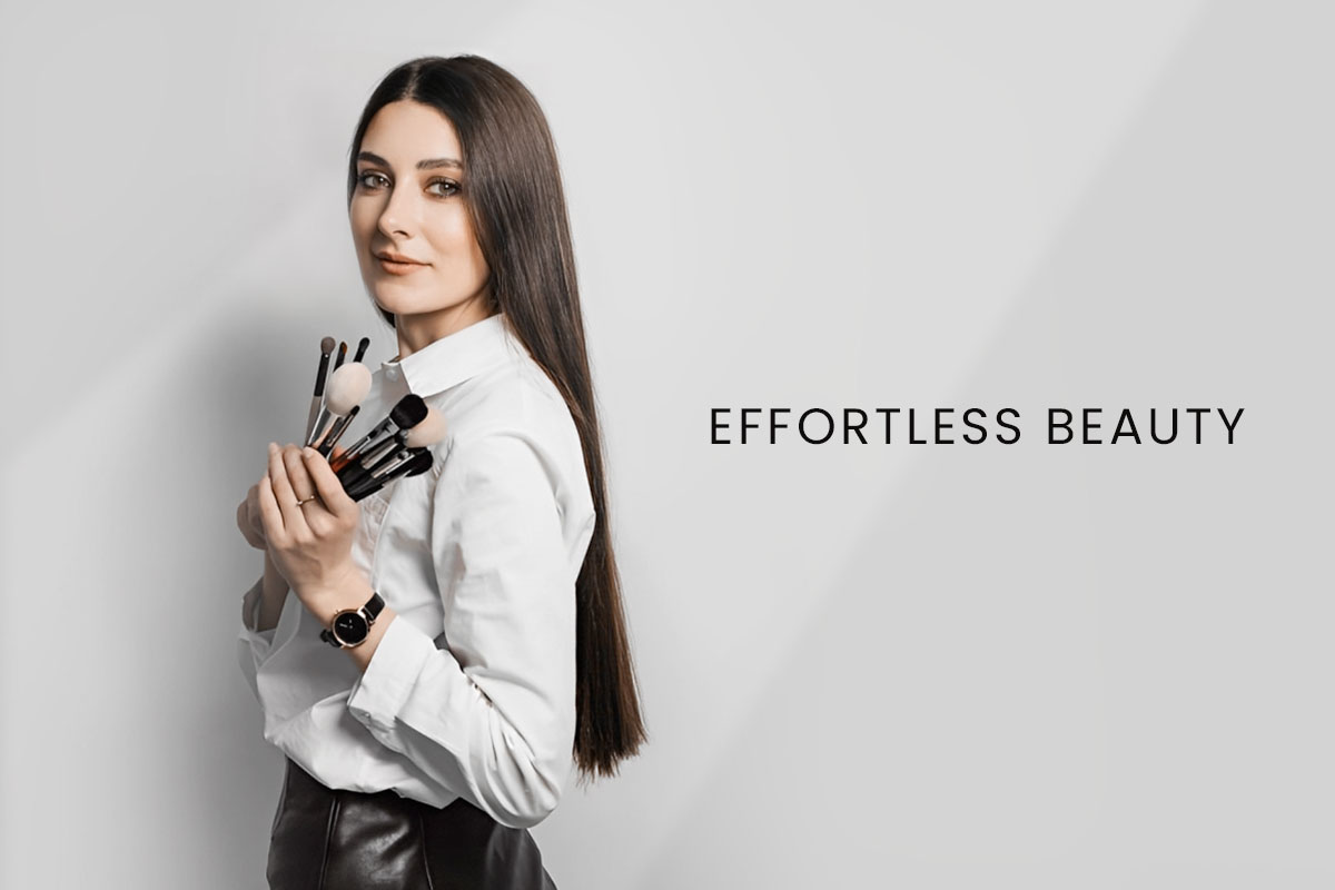387 Beautiful Esthetician Business Names 8 An esthetician holding makeup brushes next to the business name Effortless Beauty.